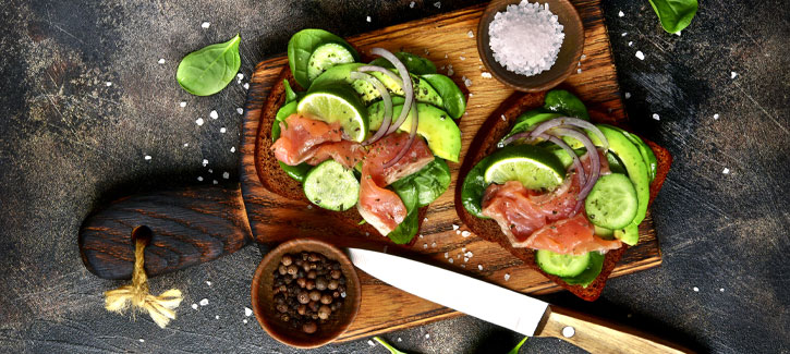 Geroosterd brood met gerookte zalm, komkommer en avocado