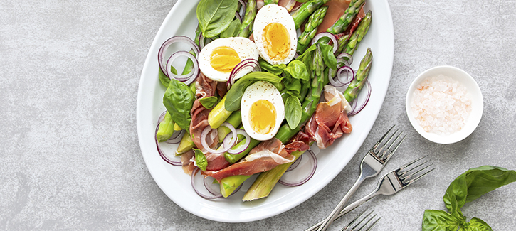 Aspergesalade met rauwe ham, gekookt ei en yoghurtsaus